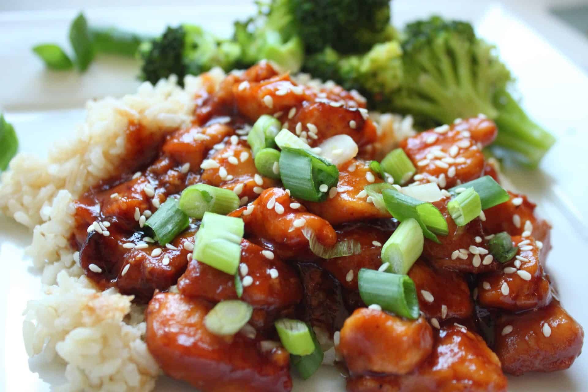 Magic in Minutes: 12 Dinners With 6 Ingredients or Less) 1 Crockpot orange chicken topped with sliced green onions and served with rice and broccoli for easy dinners with 6 ingredients or less.