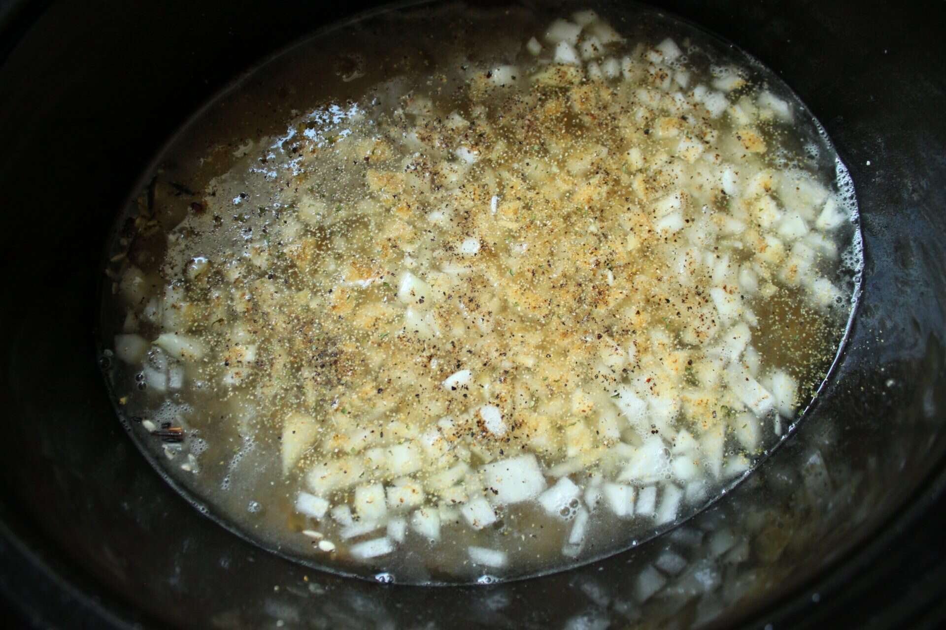 Crockpot Wild Rice with Cherries and Pecans: A Delicious Twist 2 Chopped onions and seasonings added to chicken broth in a Crockpot with rice, creating the flavor base for Crockpot wild rice with cherries and pecans.