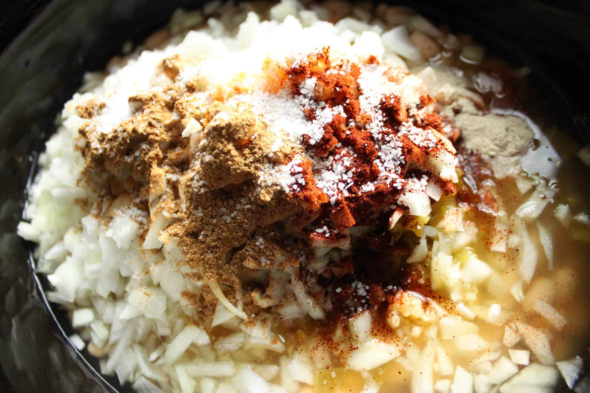 A medley of spices including cumin and chili powder added to the slow cooker, giving the Healthy Crockpot White Chicken Chili bold flavors.