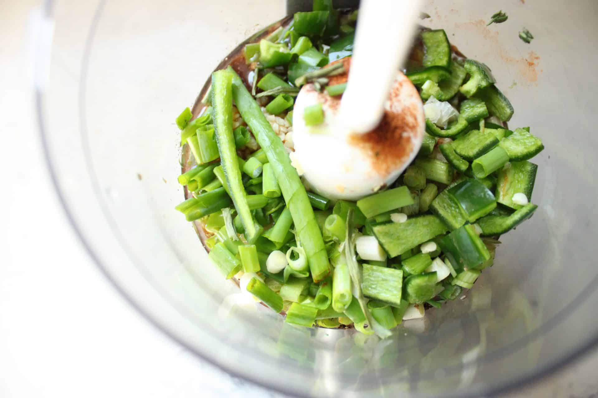 Fresh chopped green onions and other vegetables being added to the spice mixture for Easy Roasted Jerk Chicken marinade.