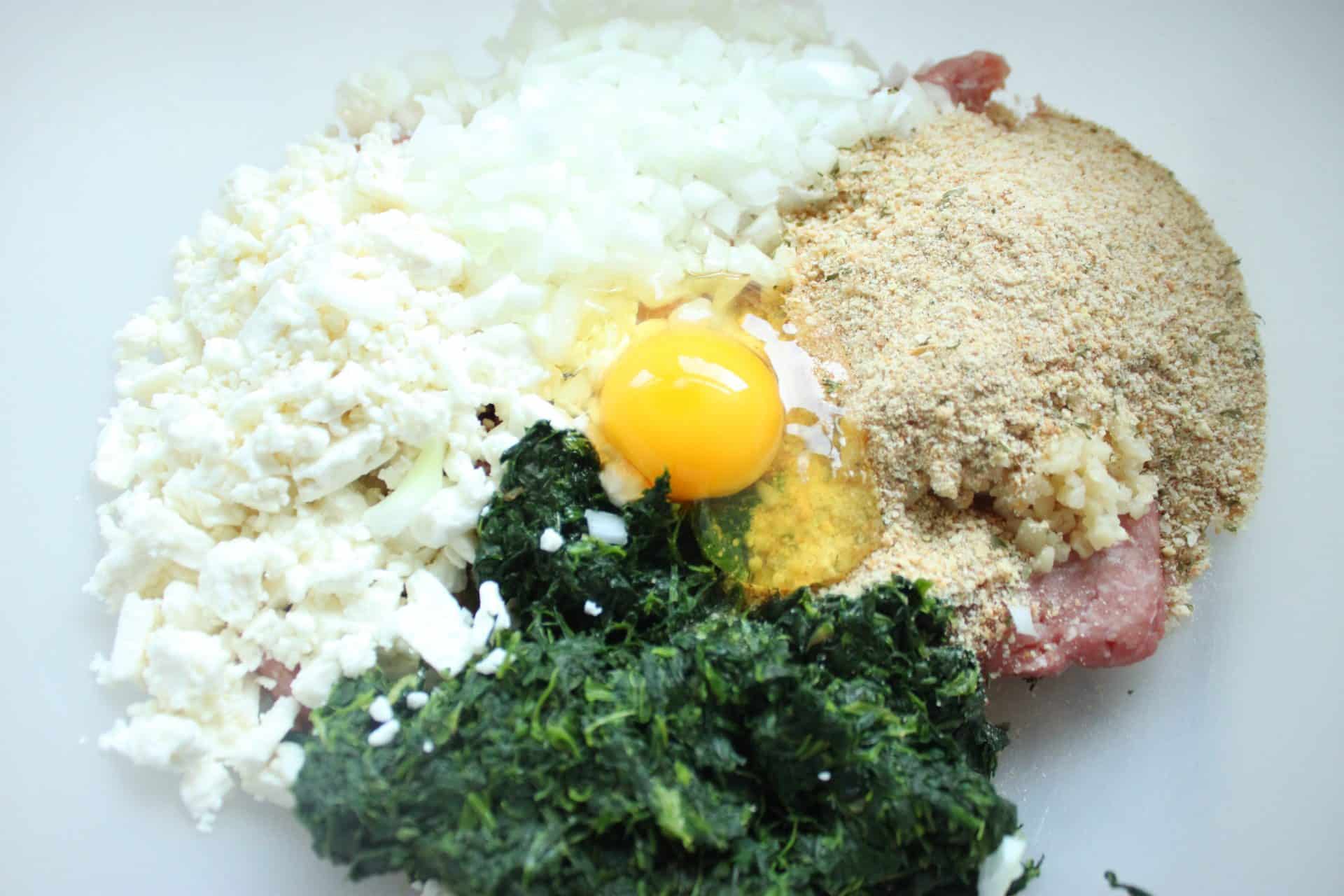 Adding eggs breadcrumbs onion and feta cheese