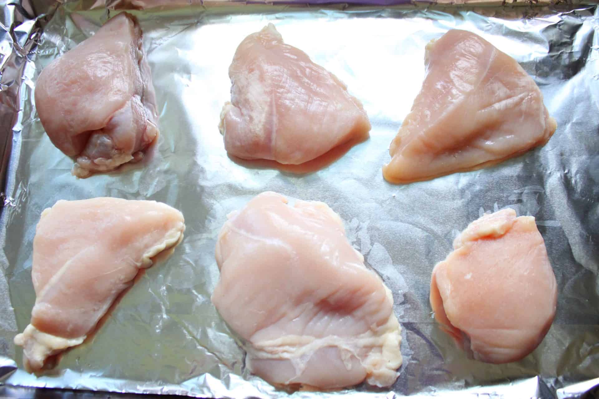 Raw Skinless and Boneless Chicken Breasts on a Cookie Sheet