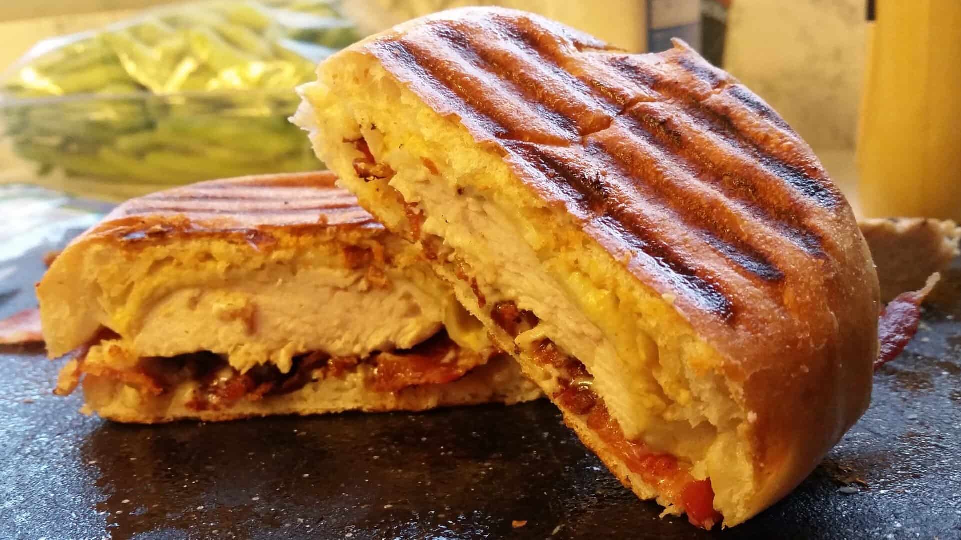 Cut Chicken Bacon Ranch Paninis on a Black Cutting Board