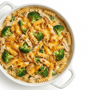 Chicken Broccoli CasseroleChicken broccoli pasta casserole with melted cheddar cheese, rotini noodles, and crispy onions in white baking dish