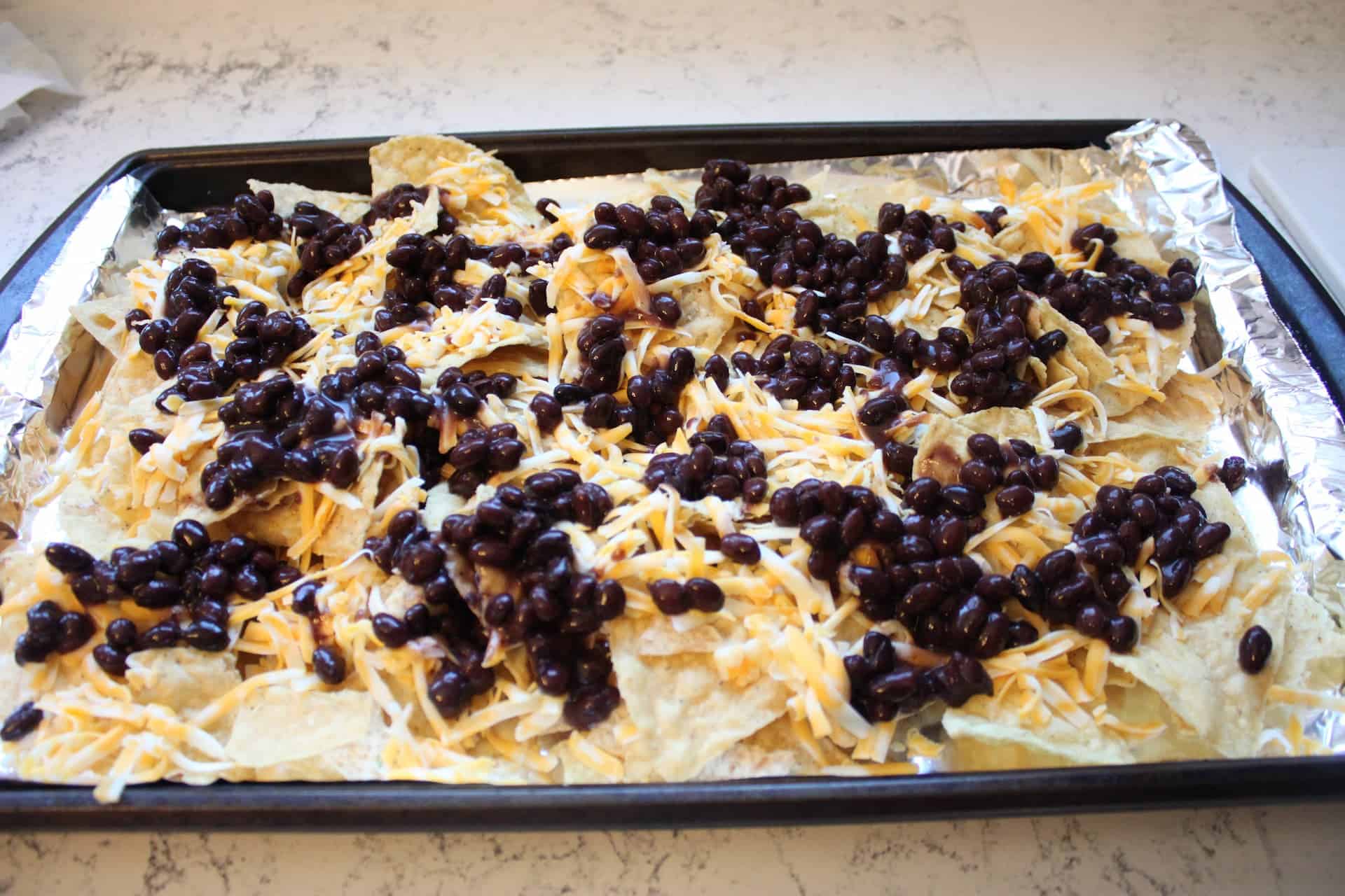 8 Ingredient Delicious Black Bean Nachos 1 Stacking the Black Bean Nachos with Chips, Beans and Cheese