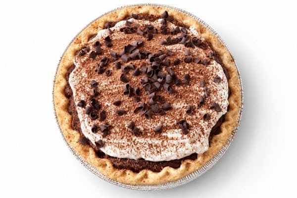 Chocolate cream pie topped with whipped cream, cocoa, and chocolate curls, viewed from overhead.