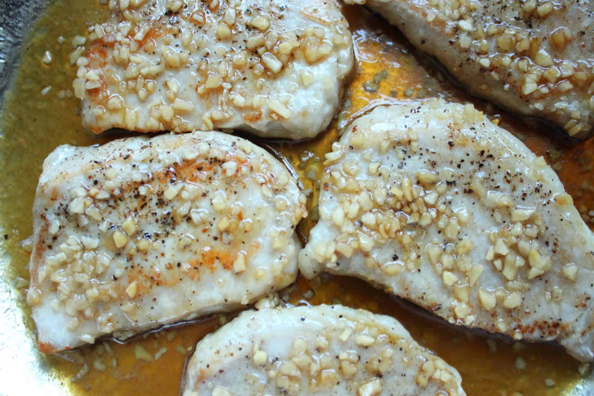 Sweet and Savory: How to Make 20-Minute Honey Glazed Pork Chops 3 Searing honey glazed pork chops in a skillet, bubbling in the flavorful glaze and creating a mouthwatering aroma.