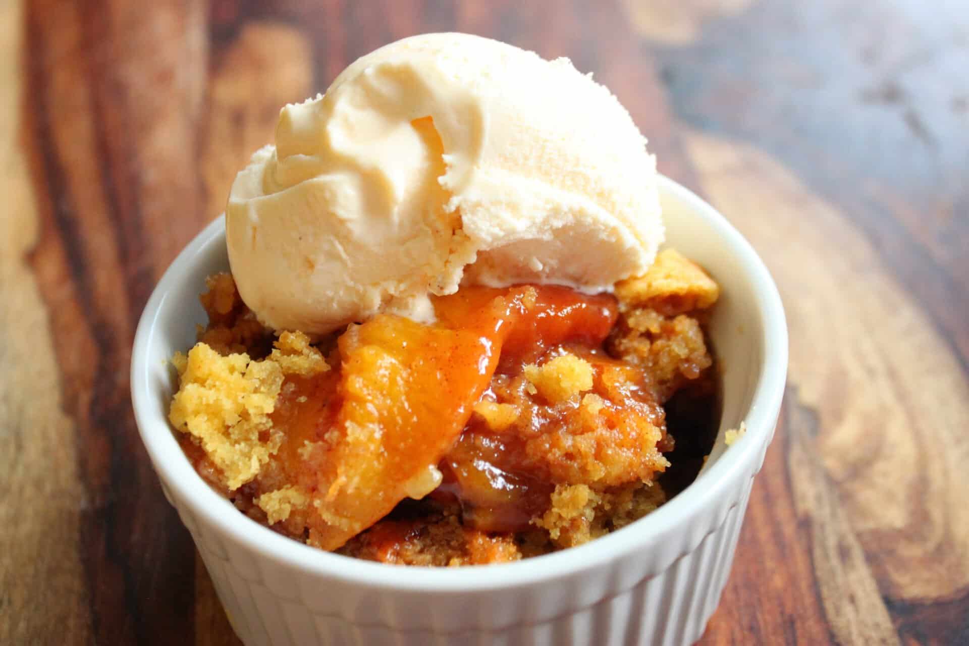 Crockpot Peach Cobbler Topped with Vanilla Ice Cream