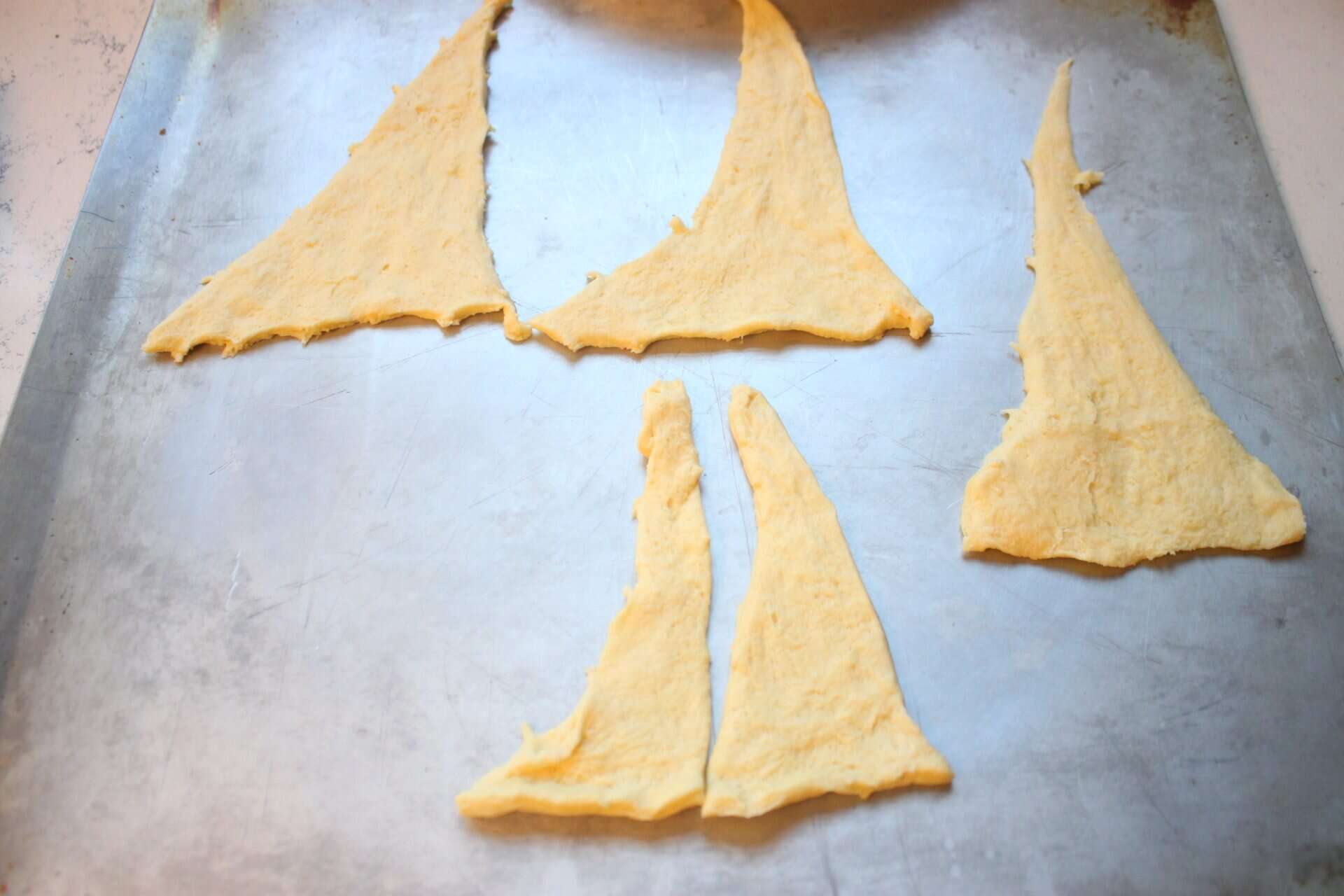 Raspberry Almond Danish: A Festive Breakfast Treat 1 Raw crescent dough triangles are separated and arranged on a baking sheet, prepped for making raspberry almond Danish.