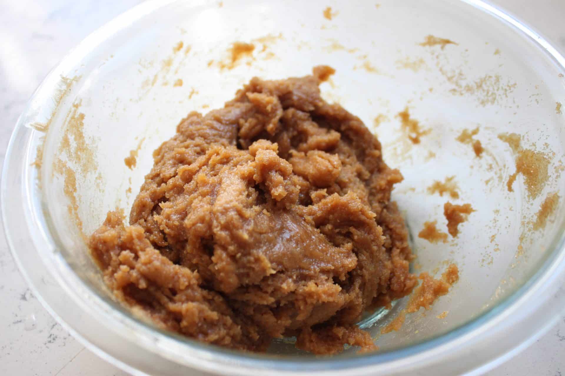 Irresistible M&M Peanut Butter Bars: 5 Simple Ingredients 3 Eggs, Peanut Butter, and Brown Sugar Mixed Together in a Clear Glass Bowl