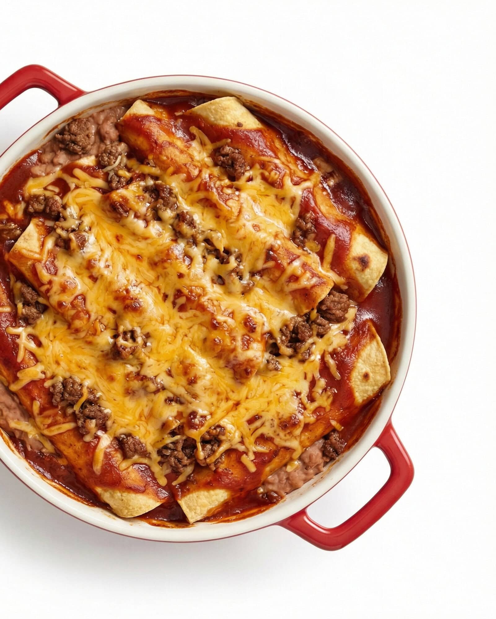 Enchilada Casserole 1 Beef enchilada casserole with melted cheddar cheese, ground beef, tortillas, and enchilada sauce in red Dutch oven