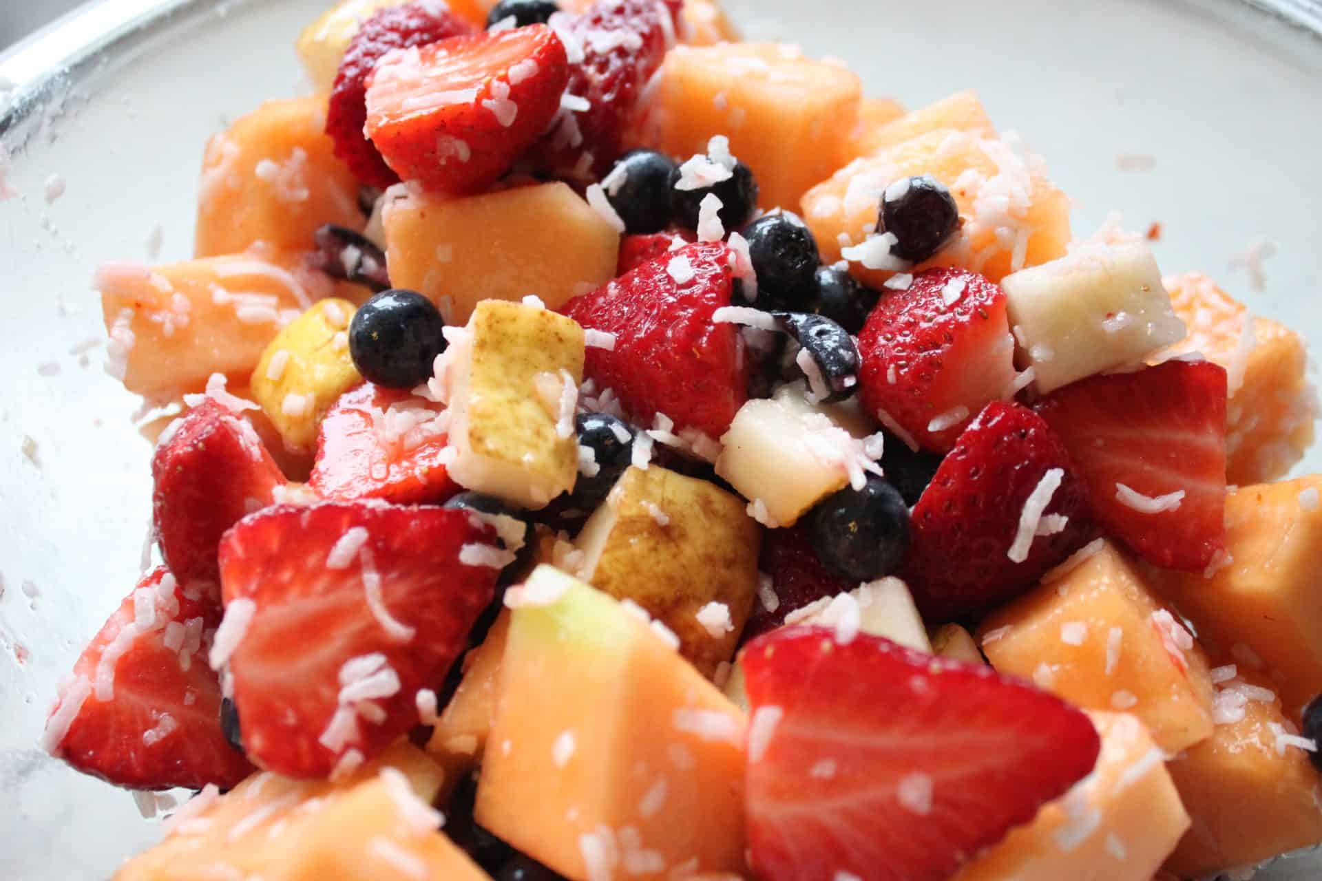 Refreshing Cinnamon Coconut Fruit Salad with a Tropical Twist 3 Fruit and Ingredients Mixed Together in Clear Glass Bowl
