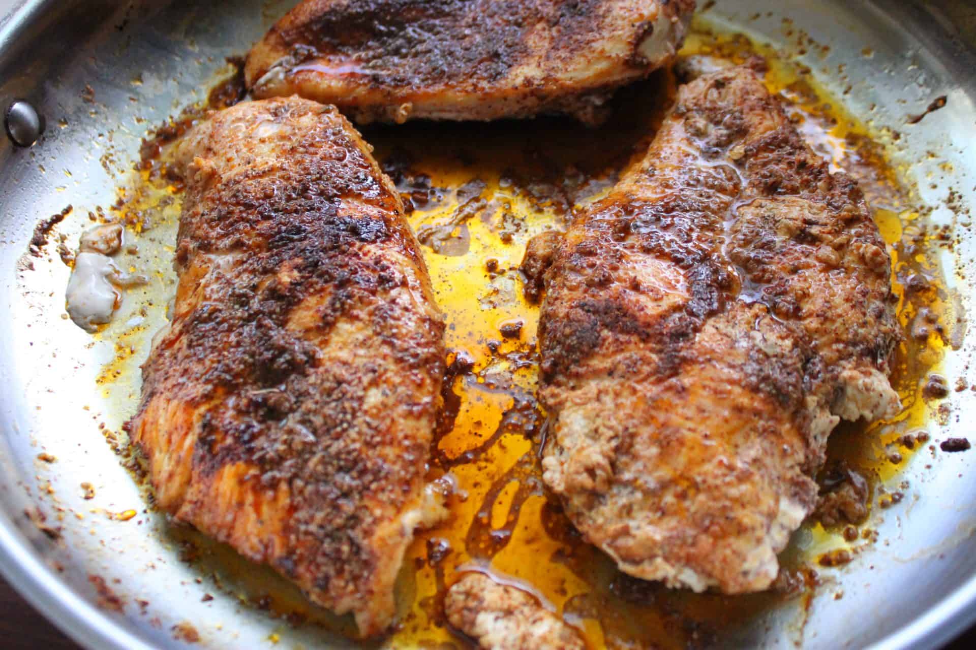 How to Make Flavor-Packed Green Chile Chicken Enchiladas at Home 3 Seasoned chicken breasts sizzling in a skillet, forming the savory base for green chile chicken enchiladas.