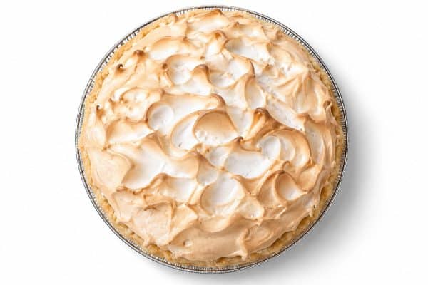Overhead view of lemon meringue pie with golden crust and swirled meringue peaks toasted light brown.
