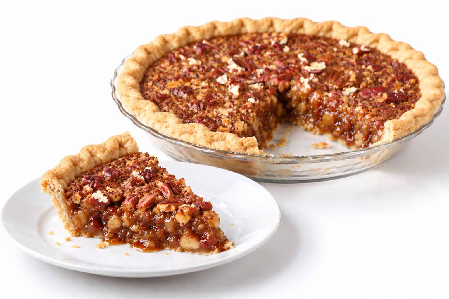 Pecan pie slice on a plate with glossy filling, with the whole pie missing one slice behind it. Title: Pecan Pie Slice Served