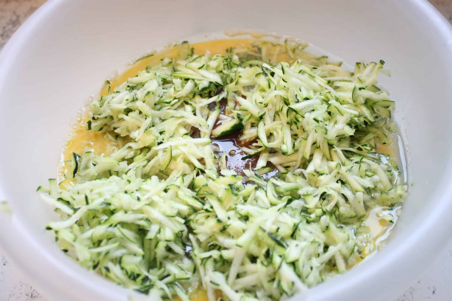 10 Simple Steps to Perfect Cinnamon Zucchini Bread 2 Grated Zucchini and Wet Ingredients in Large Plastic Bowl