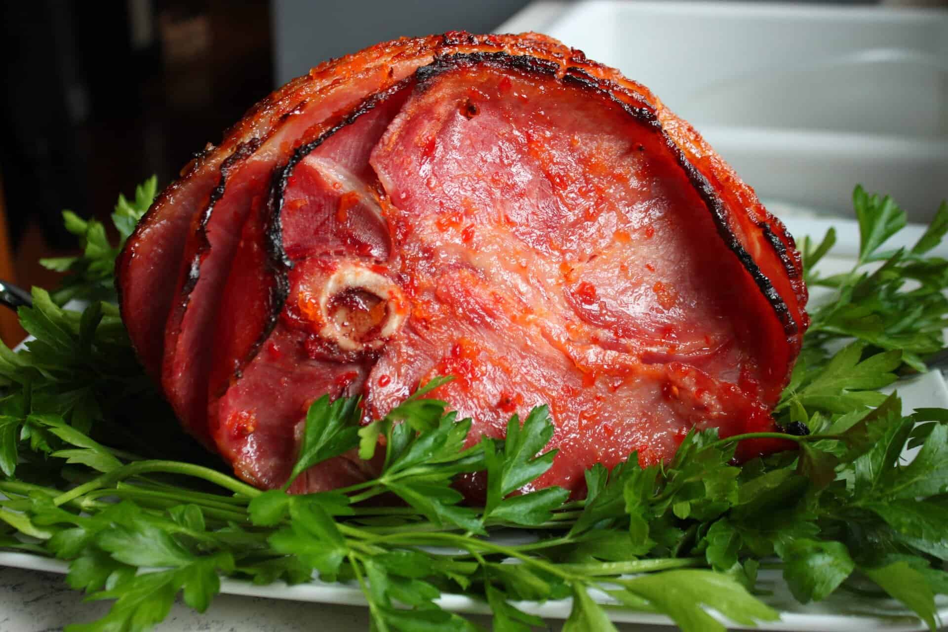 Unforgettable Holidays Start with This Prosecco and Pineapple Glazed Ham 8 Center-cut Prosecco and Pineapple Glazed Ham displayed with a garnish of parsley, showing off its caramelized glaze and holiday appeal.