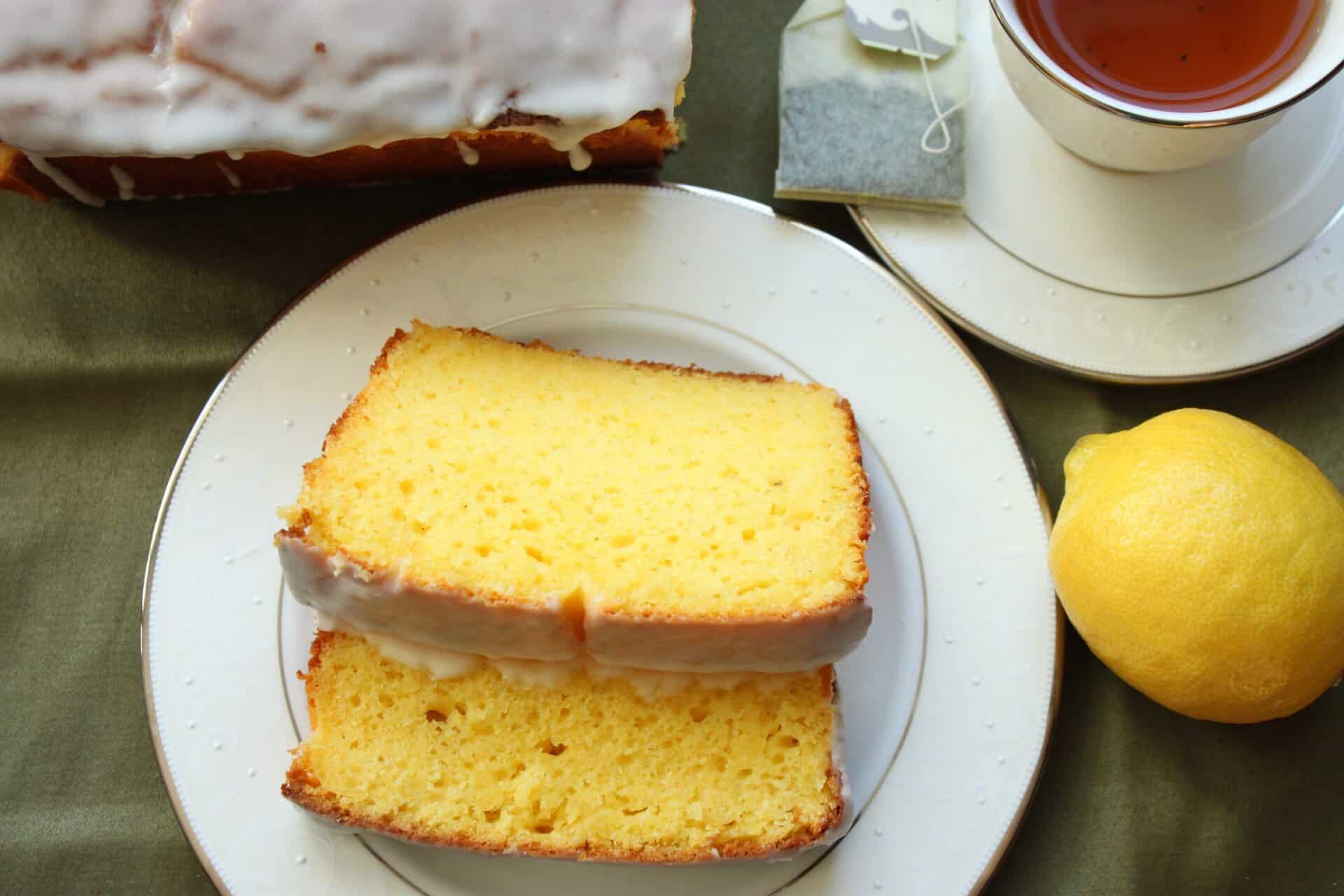 A slice of copycat Starbucks iced lemon pound cake on a white plate, highlighting the tender crumb and golden lemon color.