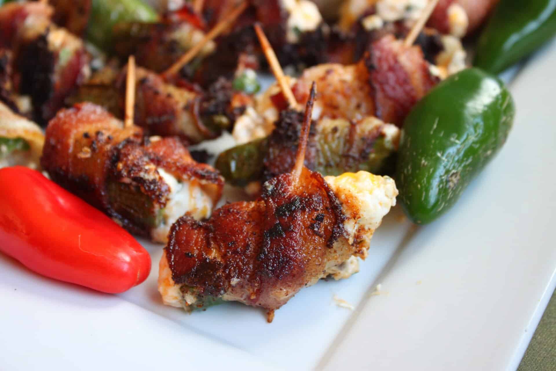 Close-up of bacon wrapped jalapeño poppers with a crispy finish and toothpicks, highlighting the smoky bacon and cheesy filling.