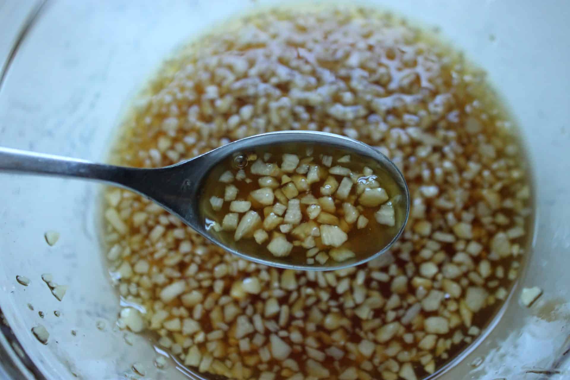 Sweet and Savory: How to Make 20-Minute Honey Glazed Pork Chops 1 Overhead view of honey glaze with minced garlic and soy sauce in a bowl, ready to pour over honey glazed pork chops.