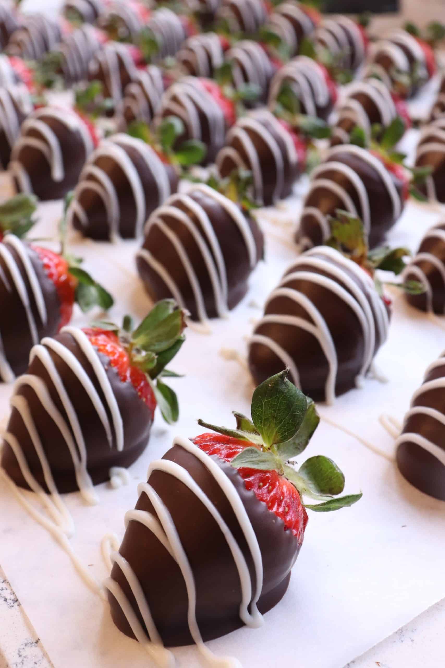Table Full of Chocolate Covered Straberries Dipped in Milk Chocolate and Drizzled with White Chocolate