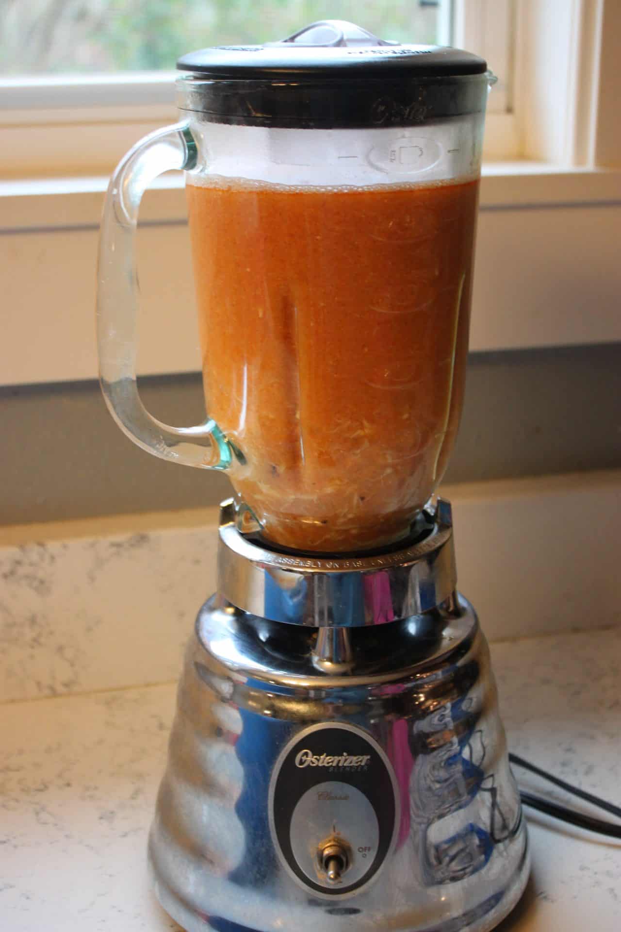 Bright orange Dungeness crab bisque being blended until smooth, the key step for the creamy texture in this 30 Minute Crab Bisque Recipe.
