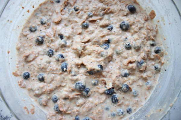 Healthy blueberry bran muffin batter fully mixed with visible blueberries and bran throughout, ready to scoop into liners.