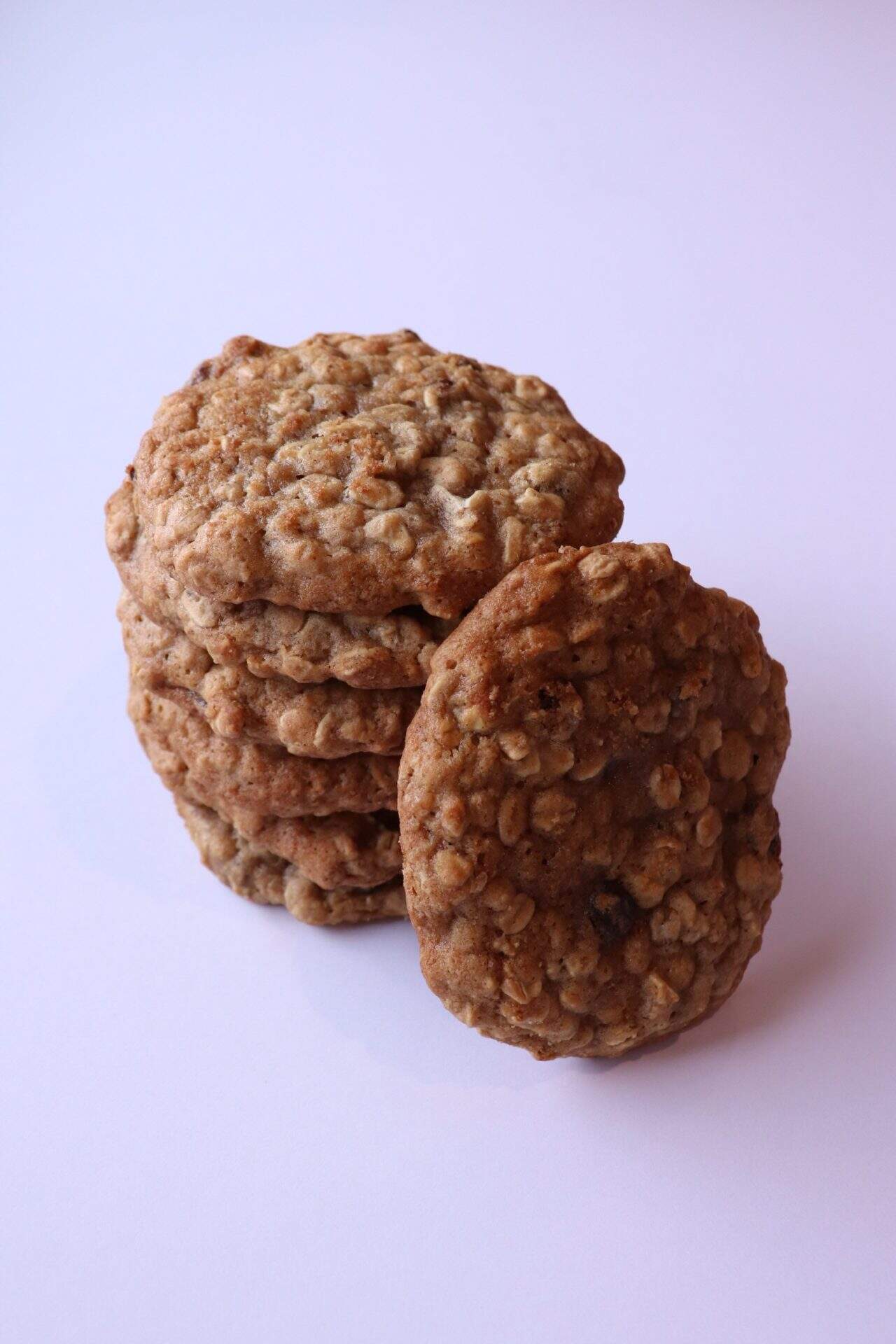 A stack of textured oatmeal cookies with rustic brown hues and visible oats, showcasing a wholesome appearance and hearty structure.