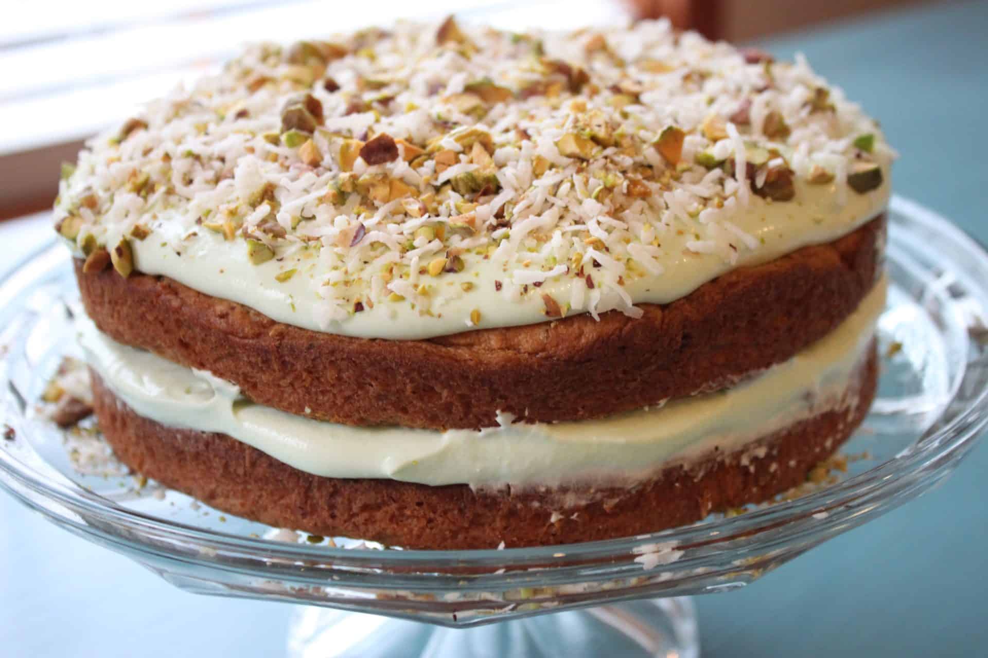 Unforgettable Holidays Start with This Prosecco and Pineapple Glazed Ham 6 Layered pistachio and coconut pudding cake topped with chopped nuts and toasted coconut, perfect for a light Easter dessert.