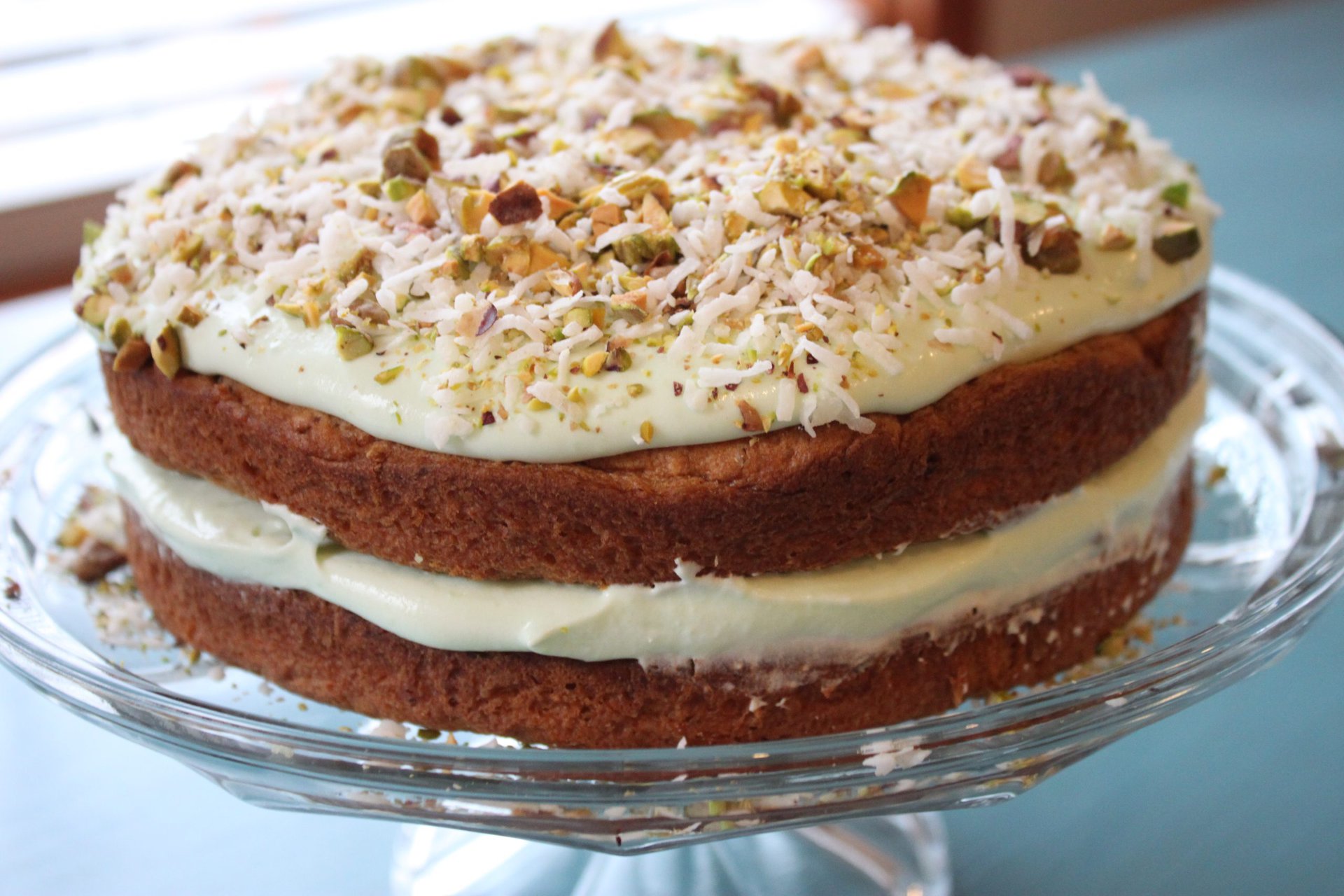 Pistachio and Coconut Pudding Cake on a Glass Dish