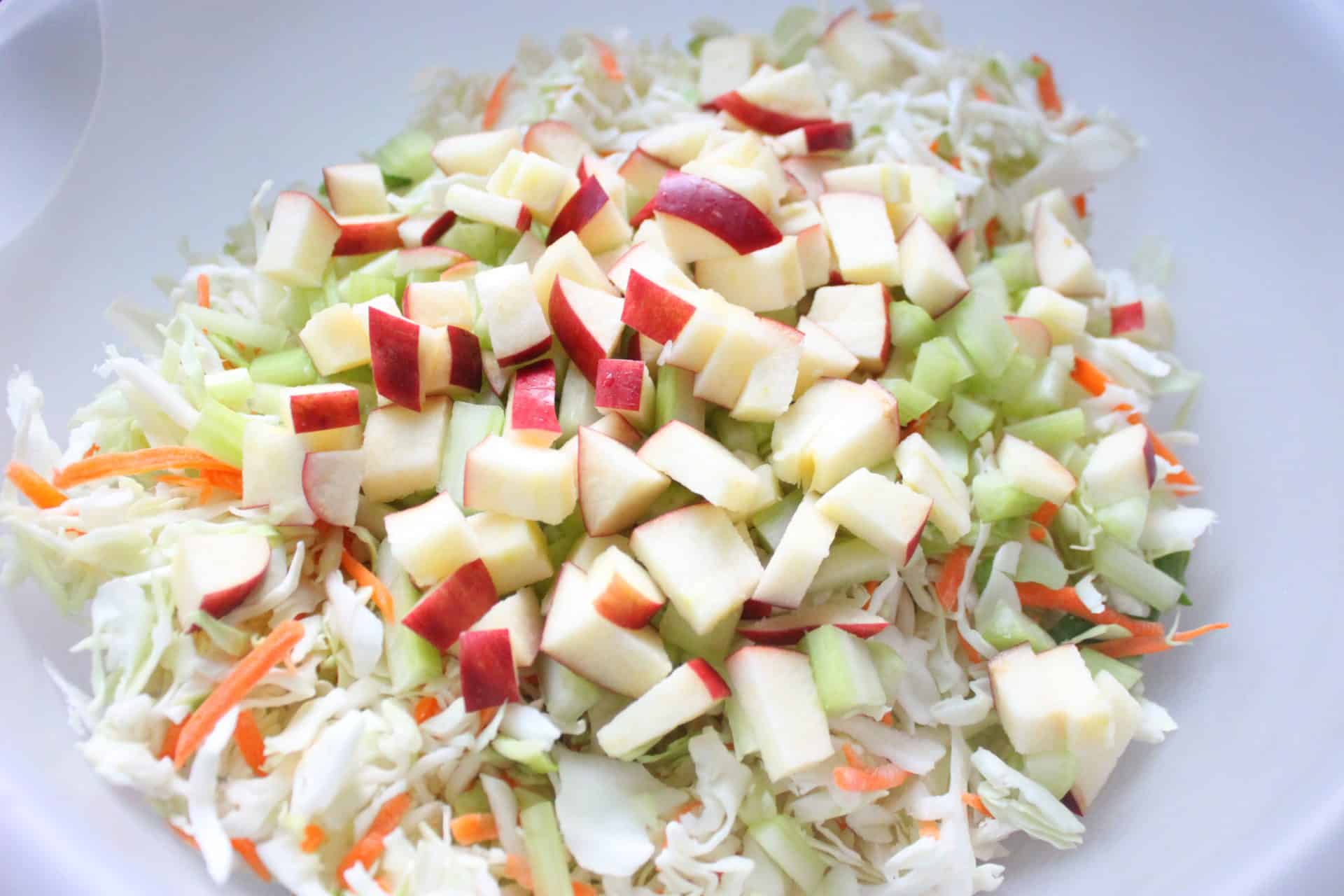 This Crisp Sweet Apple Celery Coleslaw is A Southern Favorite 1 A bowl of premixed Sweet Apple Celery Coleslaw with finely shredded cabbage, celery, and chopped apples before dressing.