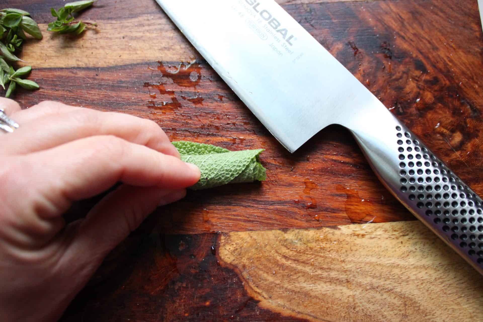 Preparing to Cut Herbs with a Global Chefs Knife on a Wooden Cutting Board