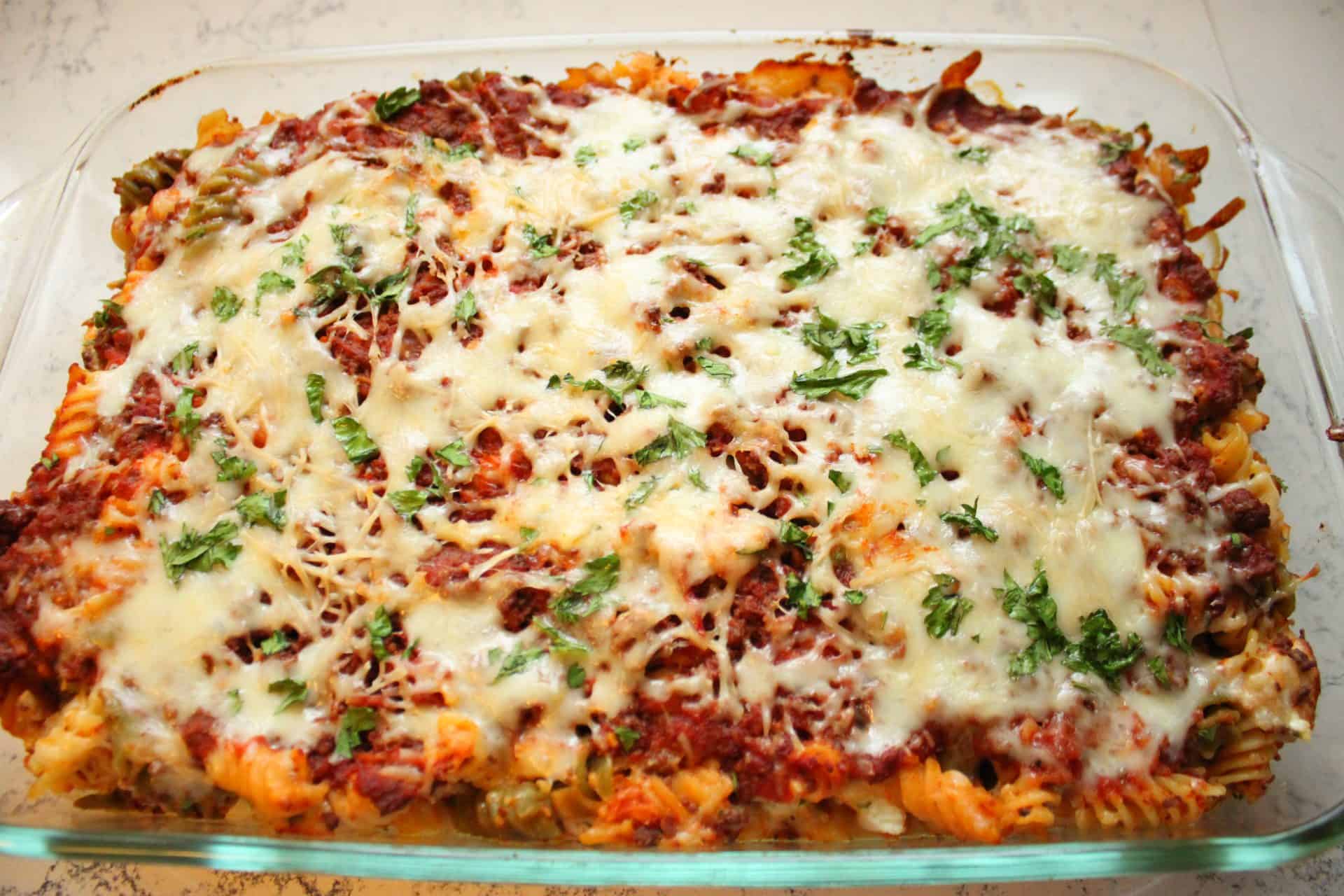 A freshly baked freezer-friendly cheesy baked ziti with golden, melted cheese and herbs, ready to be served.