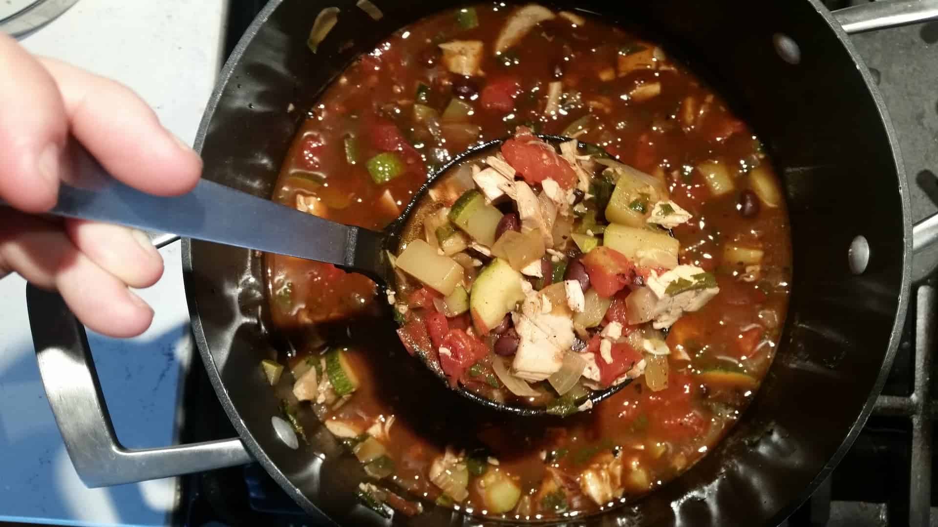 Scooping the Chicken Tortilla Soup from a Large Metal Pot