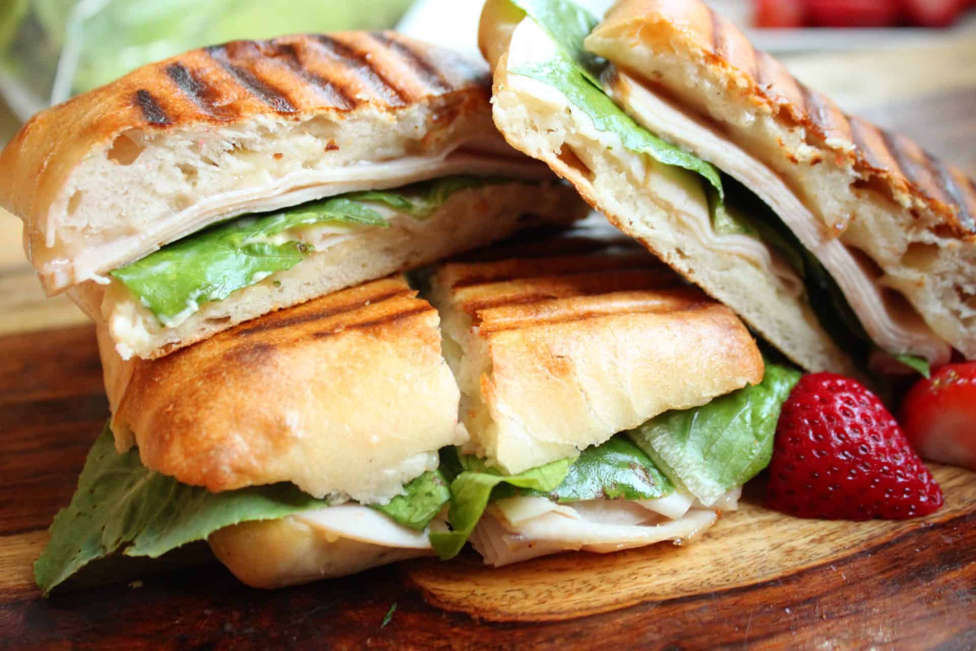 Turkey Pepper Jack Paninis cut in half and served with fresh fruit, showcasing a quick, satisfying meal that’s perfect for lunch or dinner.