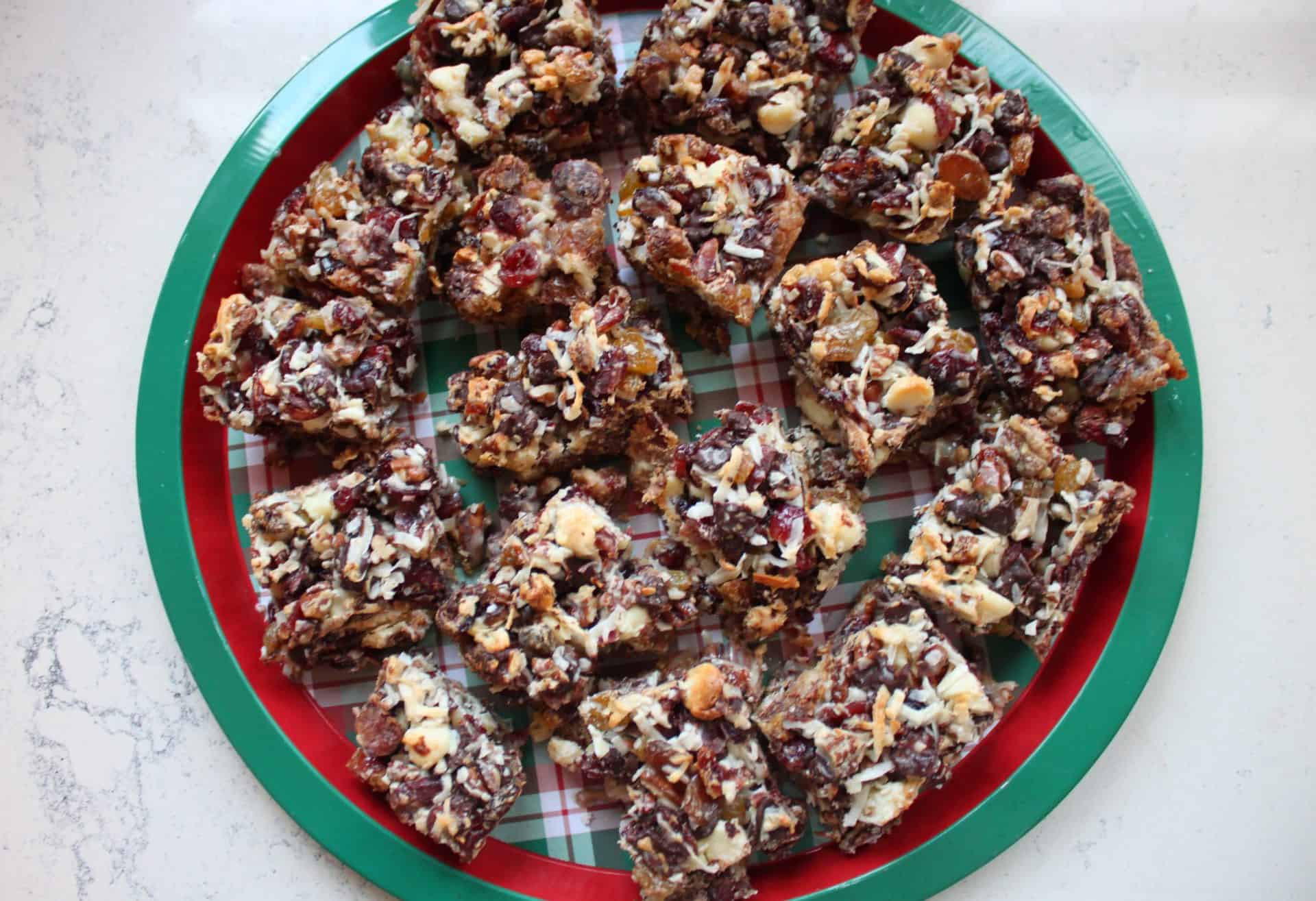 Dozens of Coconut Pecan Bars arranged on a red and green plate, ready to be served at a holiday party or festive family gathering.