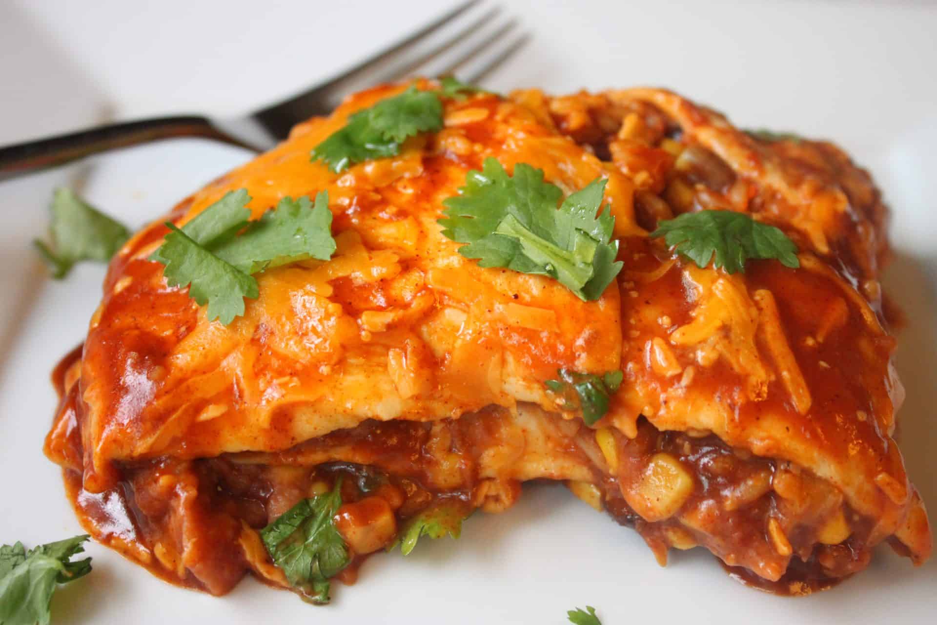 The Budget-Friendly Burrito Lasagna That Feeds 12 for $10 9 Slice of Burrito Lasagna on a White Plate