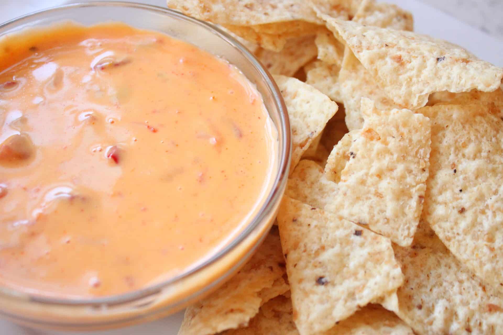 Spicy Queso Dip in a Glass Bowl with a Side or Tortilla Chips