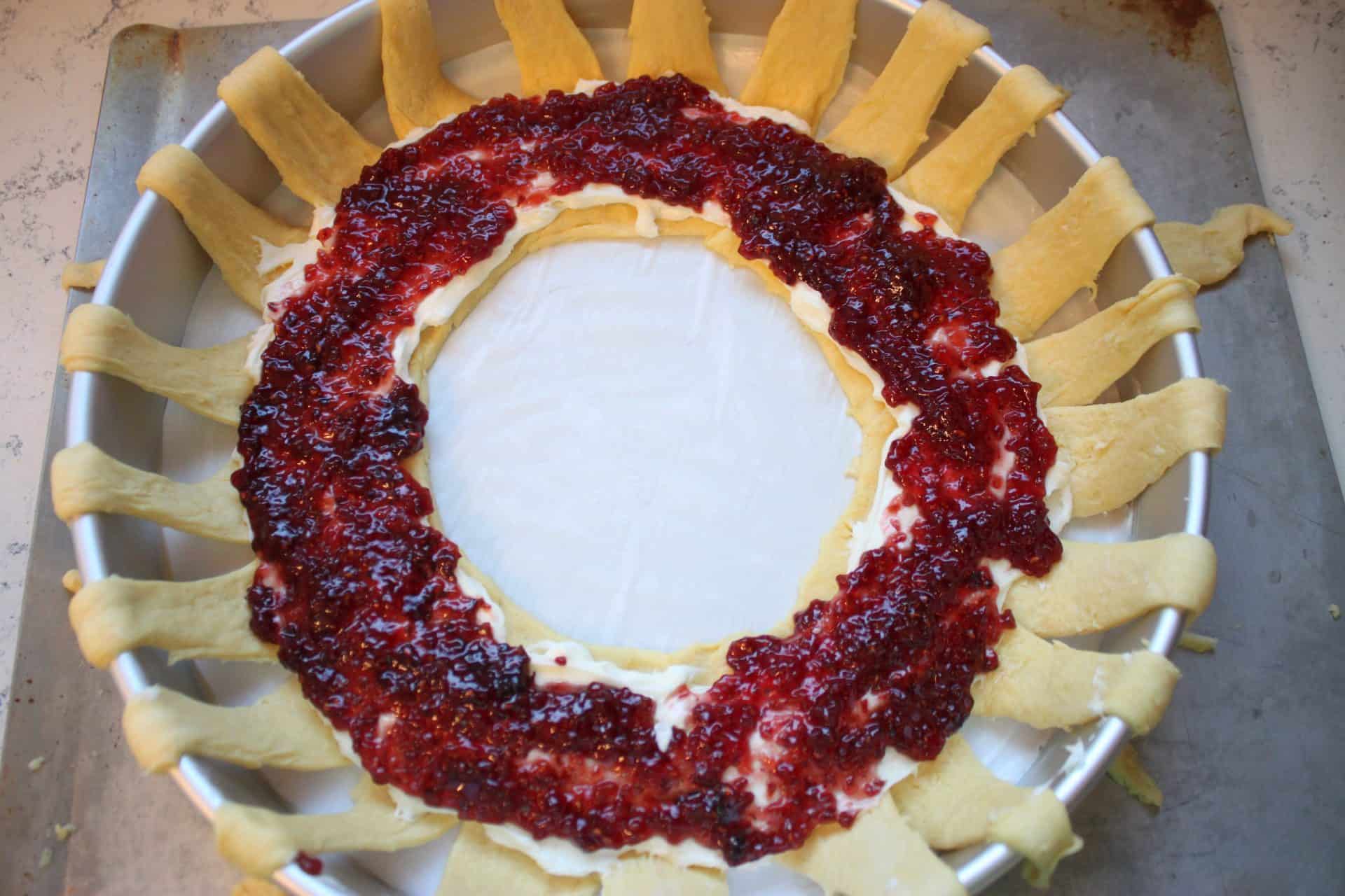 Raspberry Almond Danish: A Festive Breakfast Treat 5 Raspberry jam is spread in a thick ring around the cream cheese layer on the raspberry almond Danish wreath.