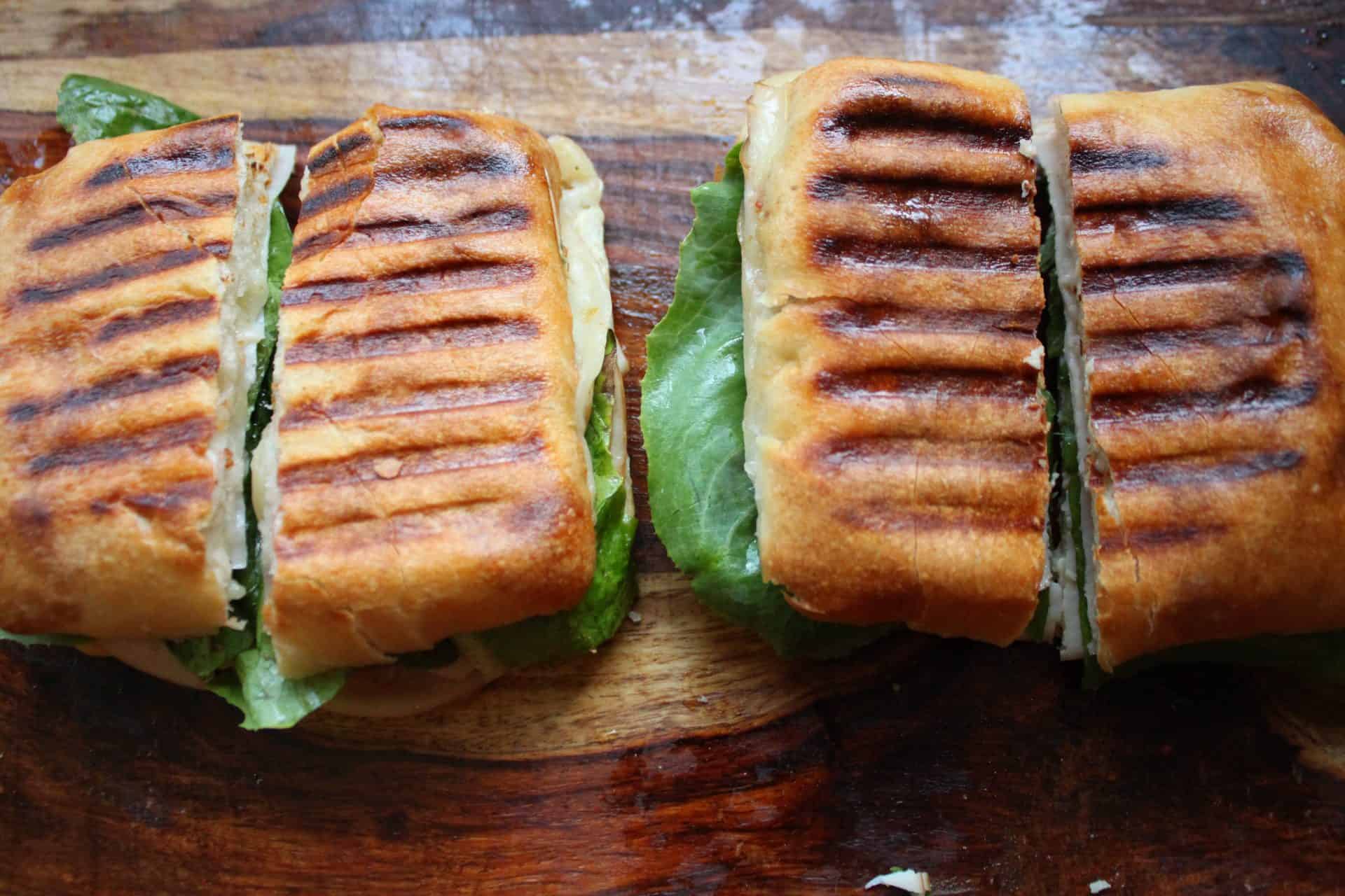 Fresh lettuce and tomato are added to the Turkey Pepper Jack Paninis after grilling, adding a refreshing crunch to each bite.
