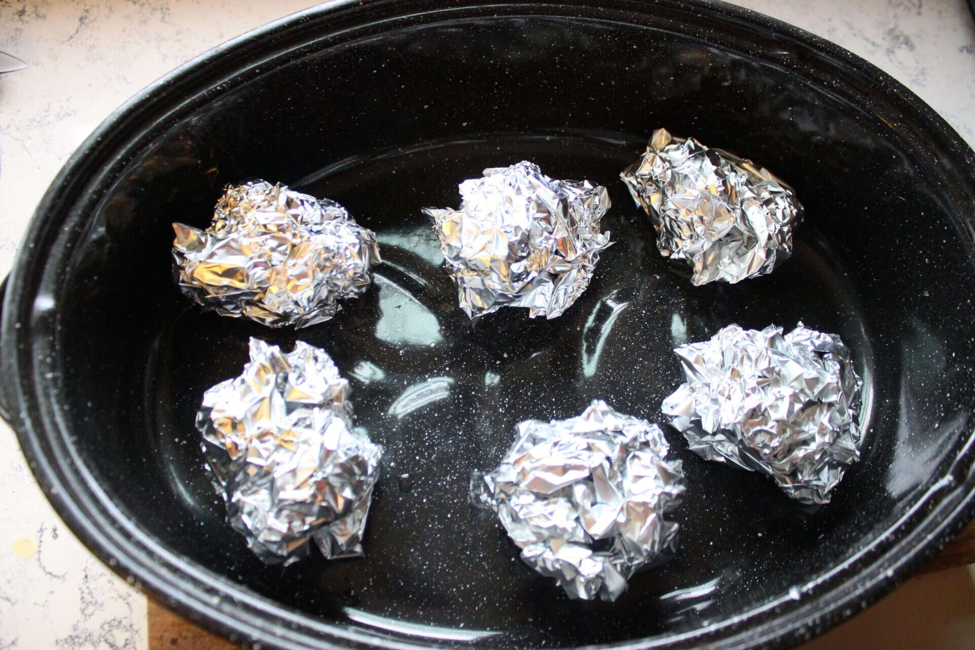 Foolproof 3-Step Tuscan-Style Roasted Turkey for the Holidays 1 Small foil balls arranged in a roasting pan, ready to hold the Tuscan-style roasted turkey above the juices for even cooking.