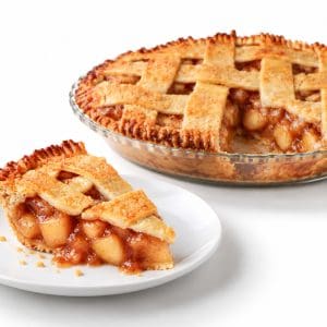 Apple pie slice on a plate with the whole pie, one slice missing, visible behind it.
