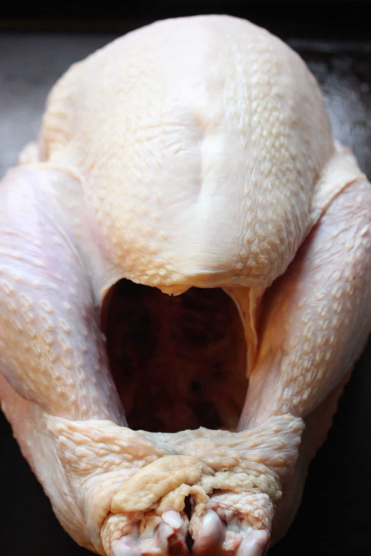 Foolproof 3-Step Tuscan-Style Roasted Turkey for the Holidays 2 Raw Tuscan-style roasted turkey with skin intact, showing the cleaned bird before stuffing and seasoning for the oven.