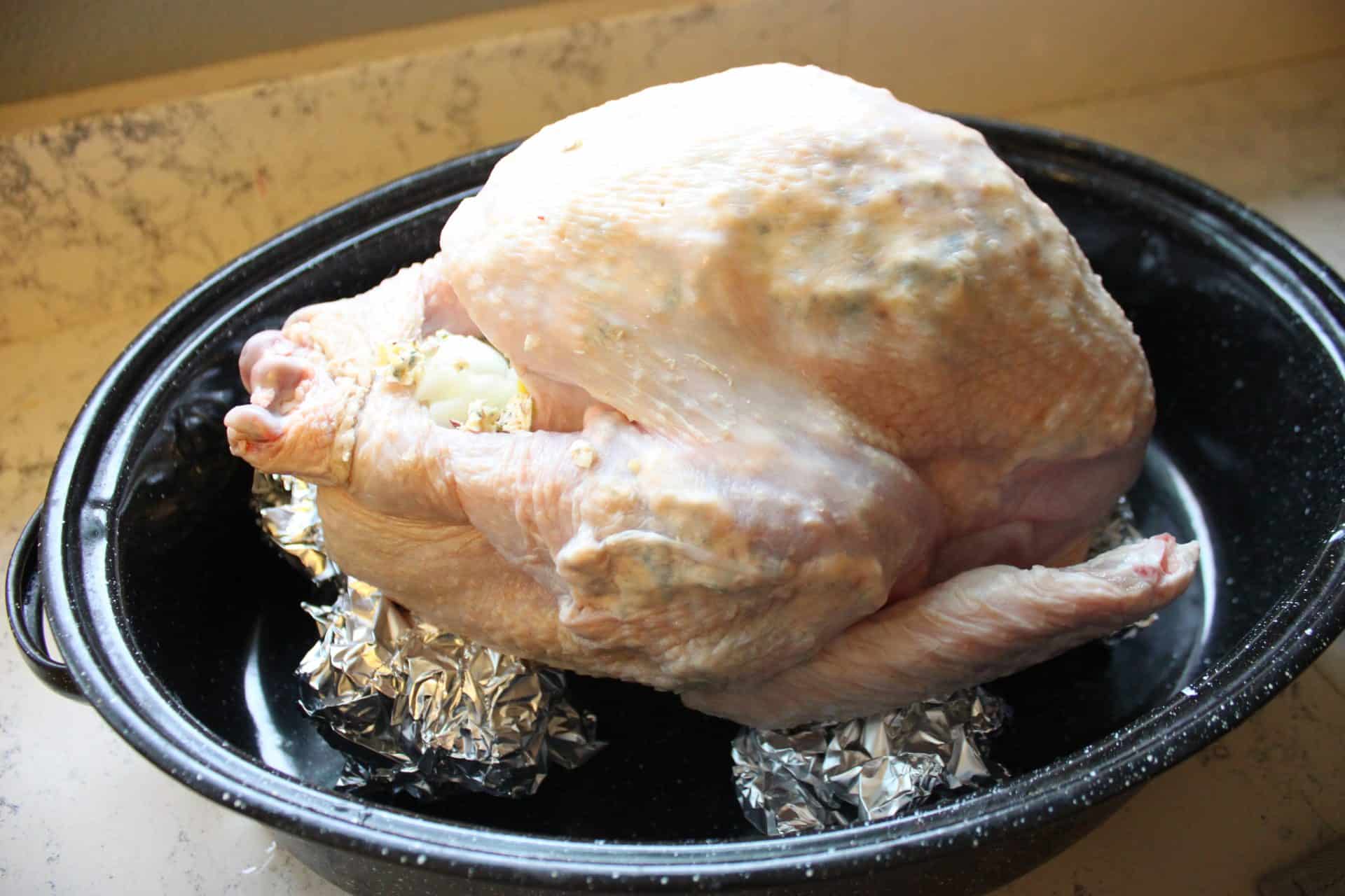 Foolproof 3-Step Tuscan-Style Roasted Turkey for the Holidays 12 Raw Tuscan-style roasted turkey placed on foil balls in a roasting pan, ready for the oven to get perfectly crisp.