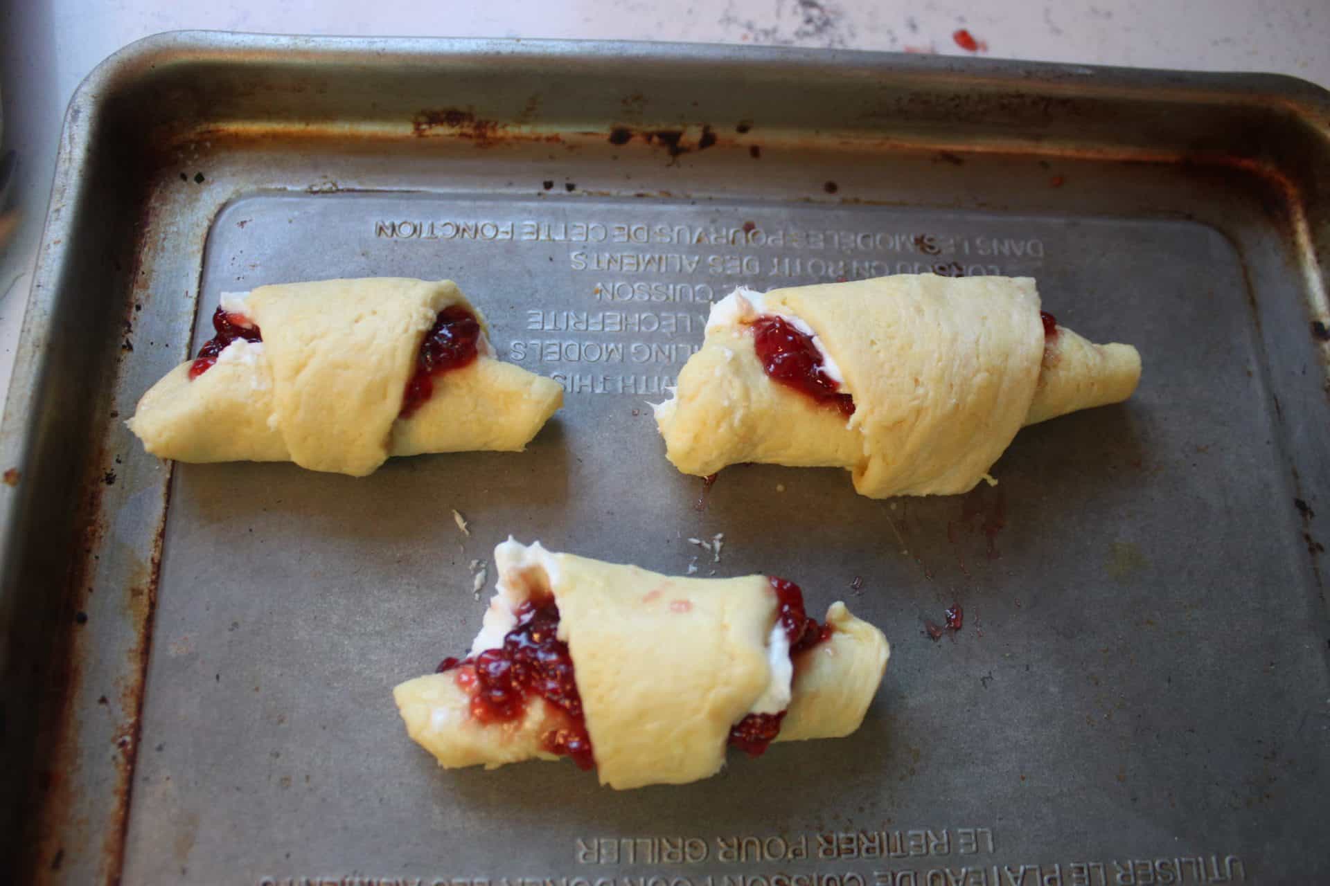 Raspberry Almond Danish: A Festive Breakfast Treat 9 Two raspberry almond crescent rolls filled with jam and baked separately on a baking sheet as a simplified version.